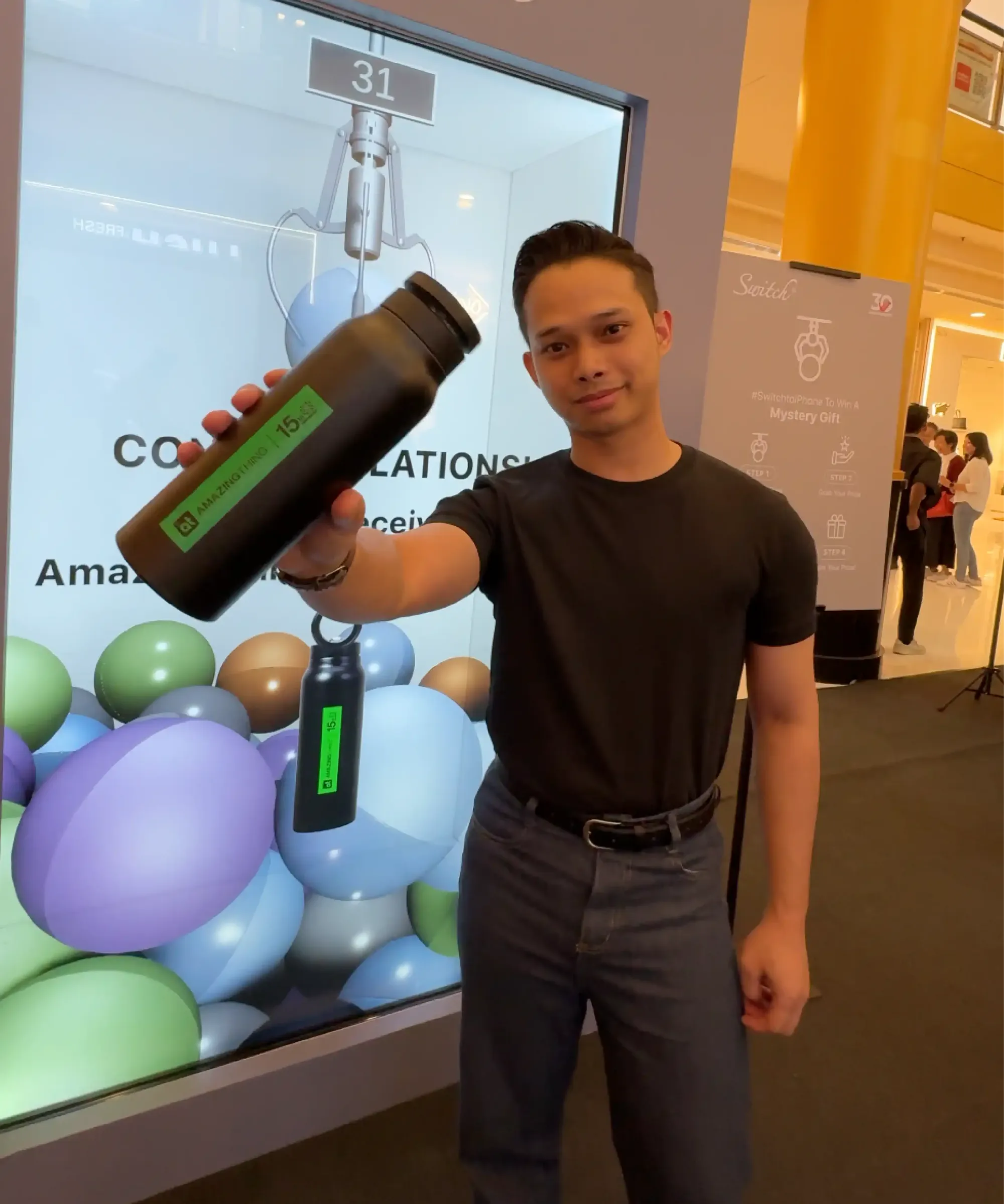 Winner collecting a real prize redeemed from the digital claw drop, no plastic capsules dispensed