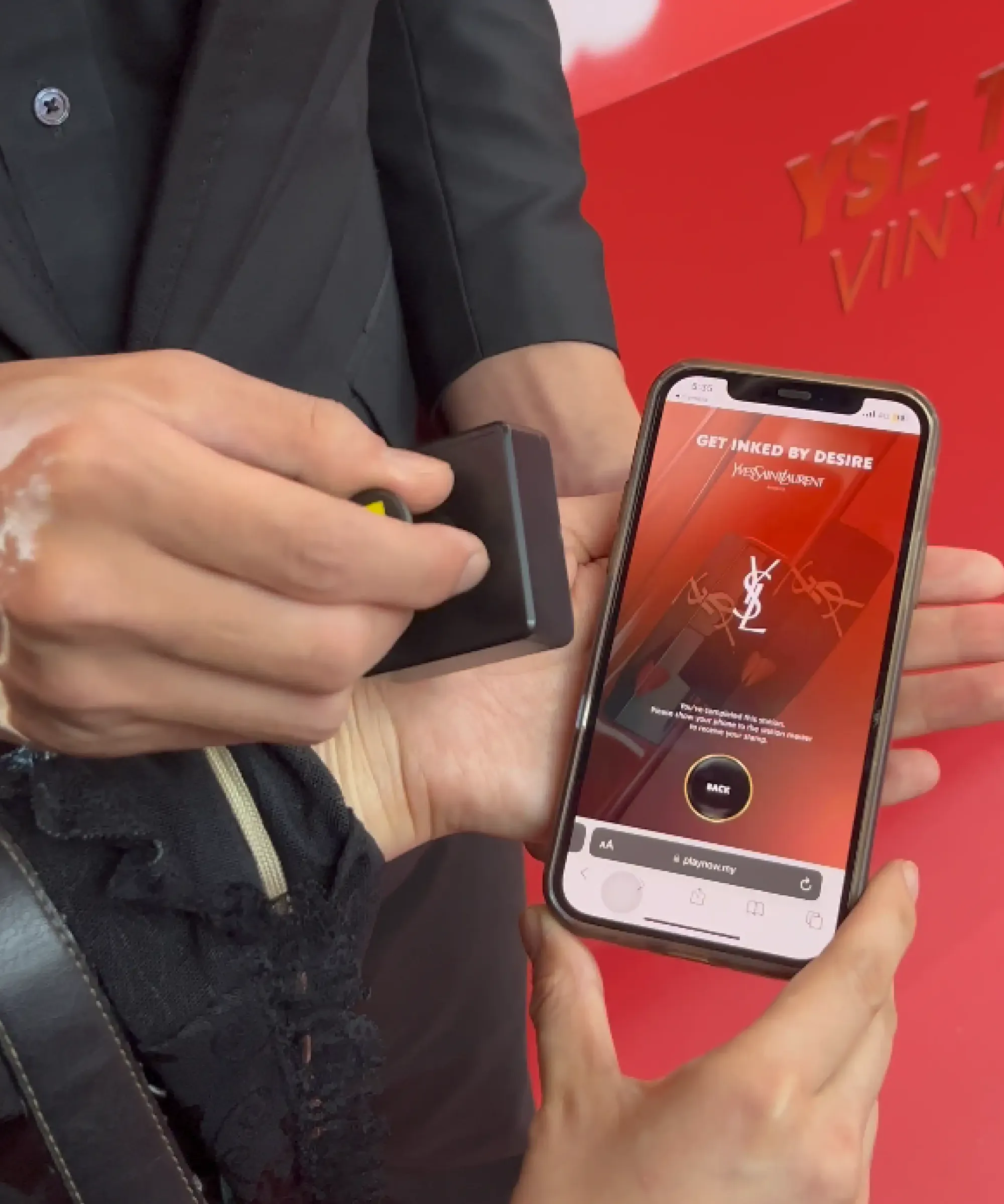 YSL The Inks roadshow — smart stamp pressed onto the guest's phone, collecting the station digitally with no paper card